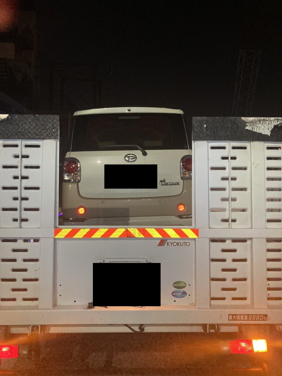 積載車に積み終えた軽自動車を後方から写した写真