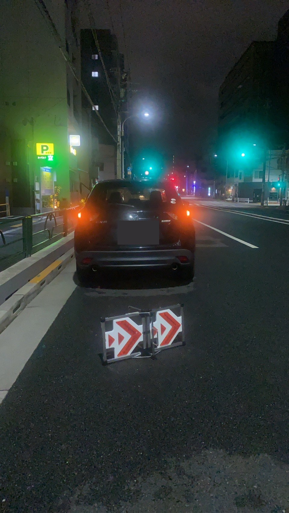 夜間の路上で停車した対象車両と安全標識を撮影