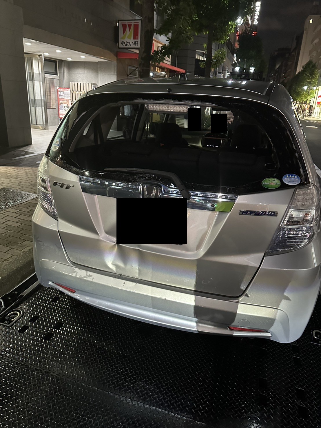 リアガラスが割れ、バックドア付近がへこんだ車両の後方（ナンバープレートはマスク処理）