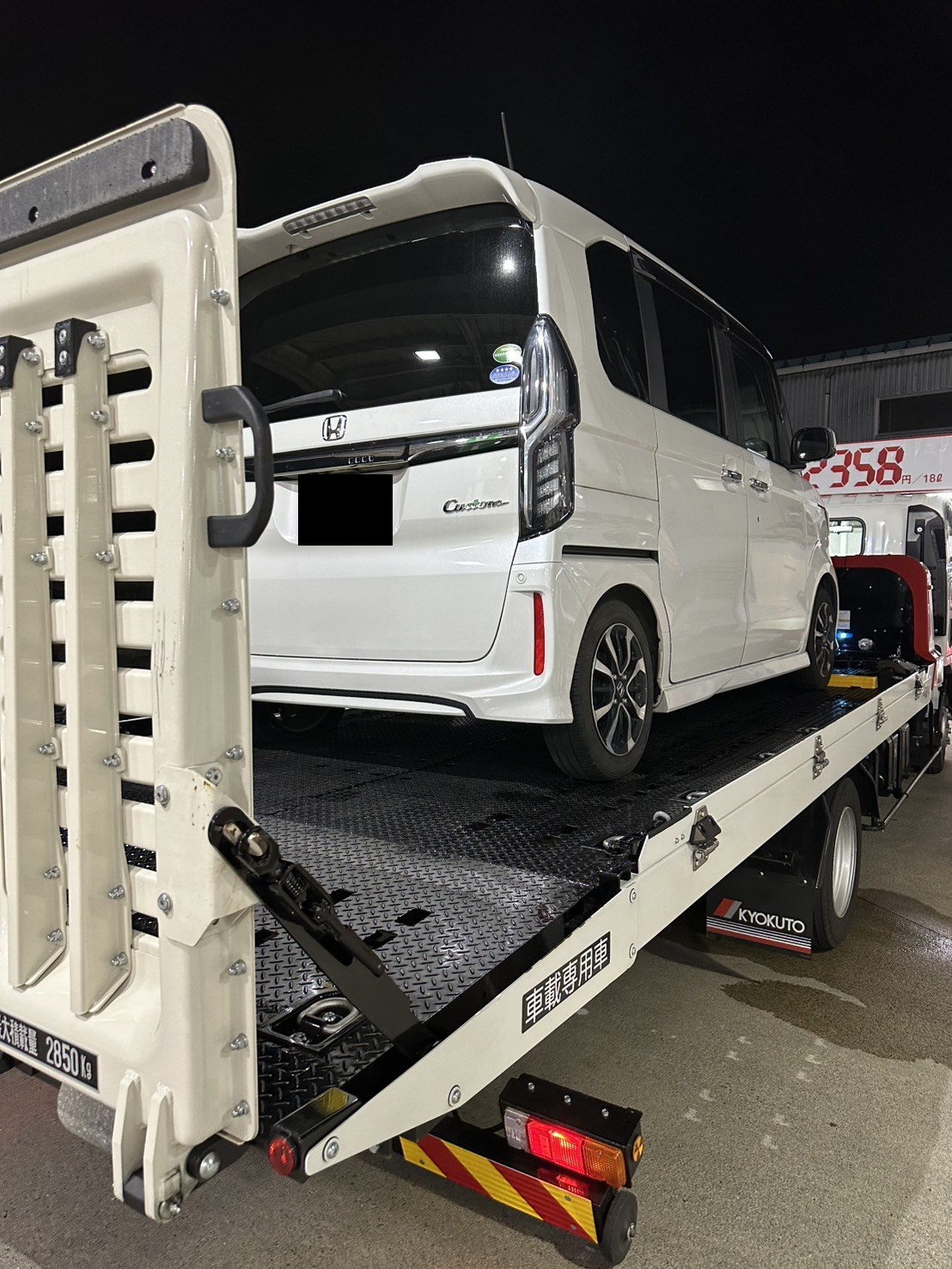 積載車の荷台に載せた軽ワゴンを後方から見た様子（ナンバープレートはマスク処理）