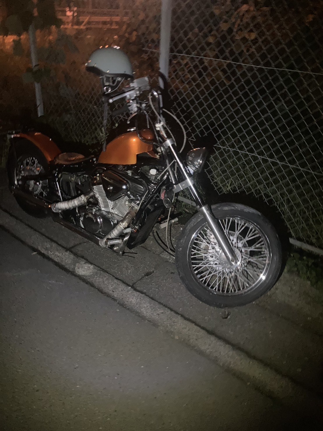 夜間、道路脇に停められた大型バイクを右前方から見た様子