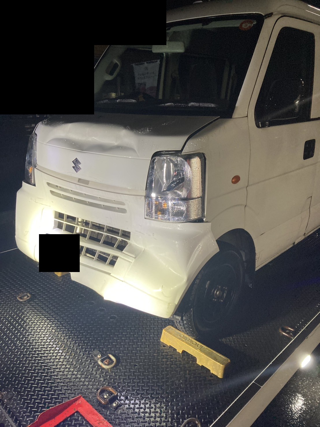 積載車の荷台に載せた軽バンを前方から見た様子（ナンバープレートと背景はマスク処理）