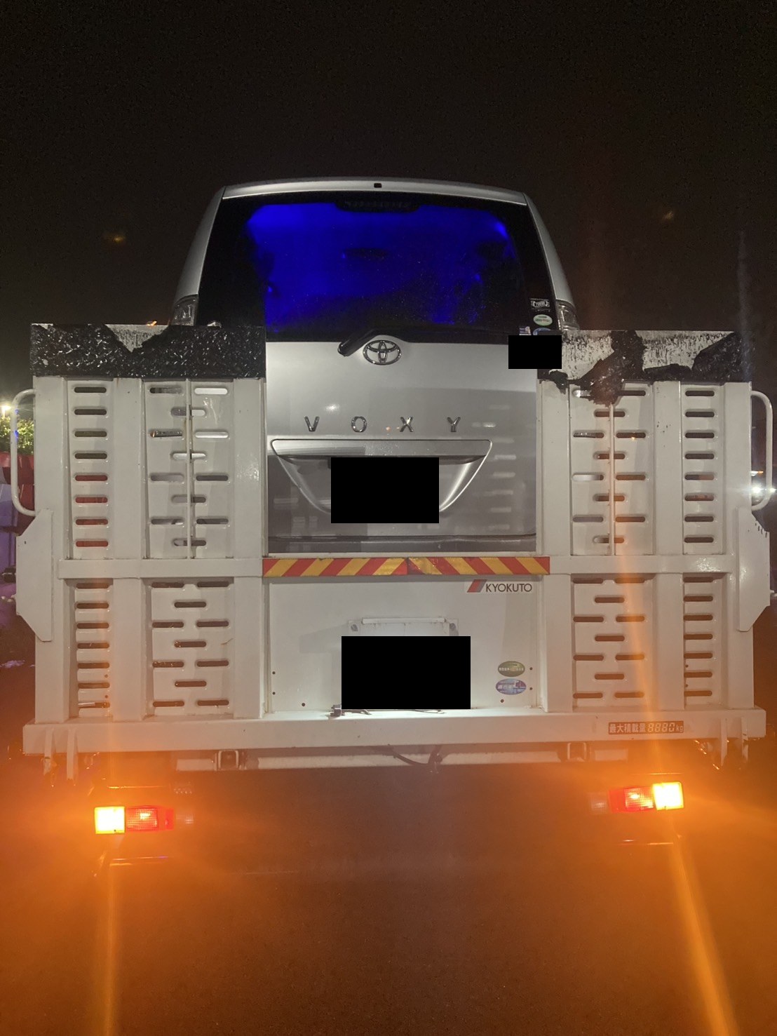 積載車の荷台に載せたミニバンを後方から見た様子（お車と積載車のナンバープレートはマスク処理）