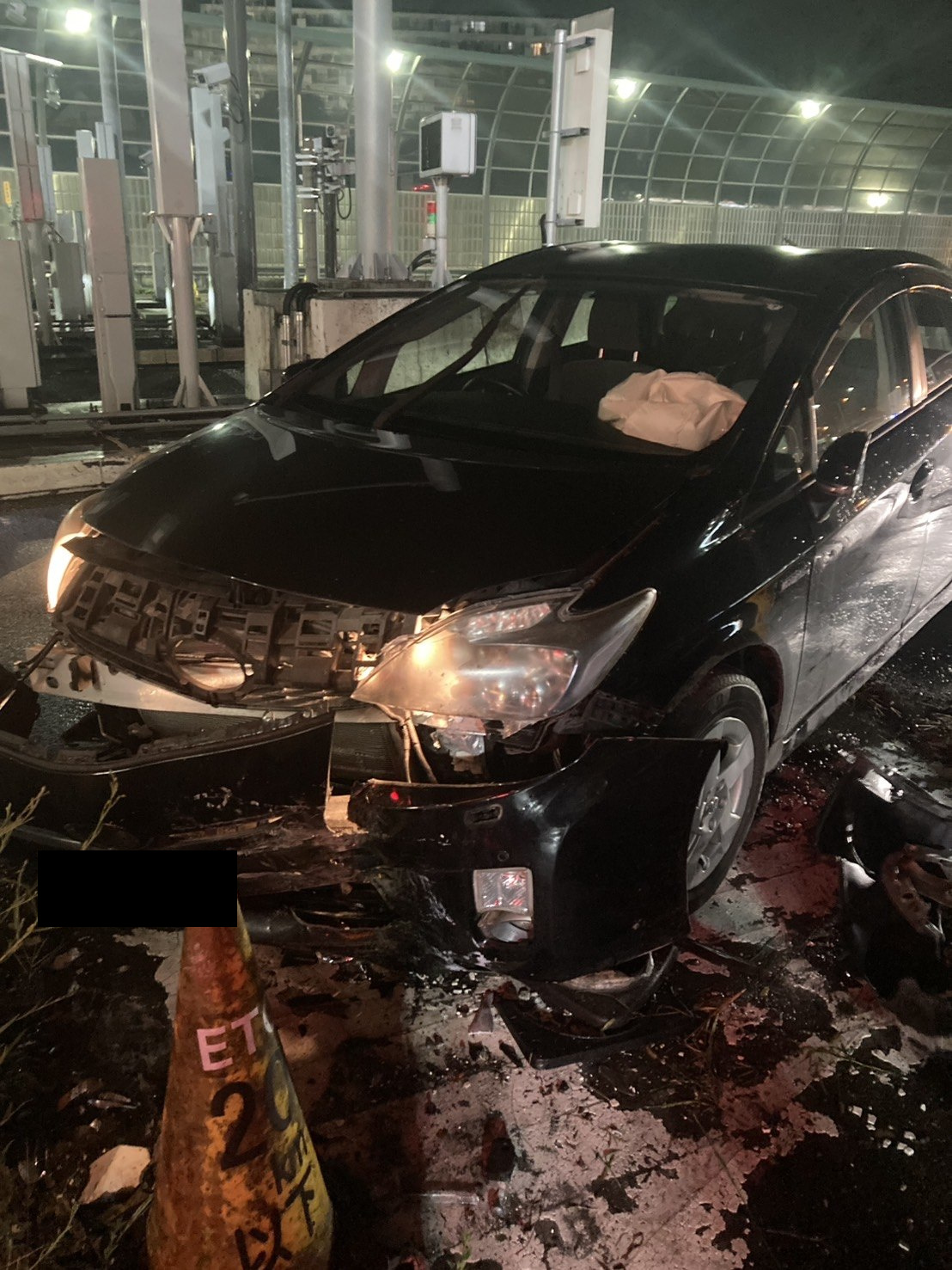 前部の破損と周囲に散乱した部品が確認できる車両