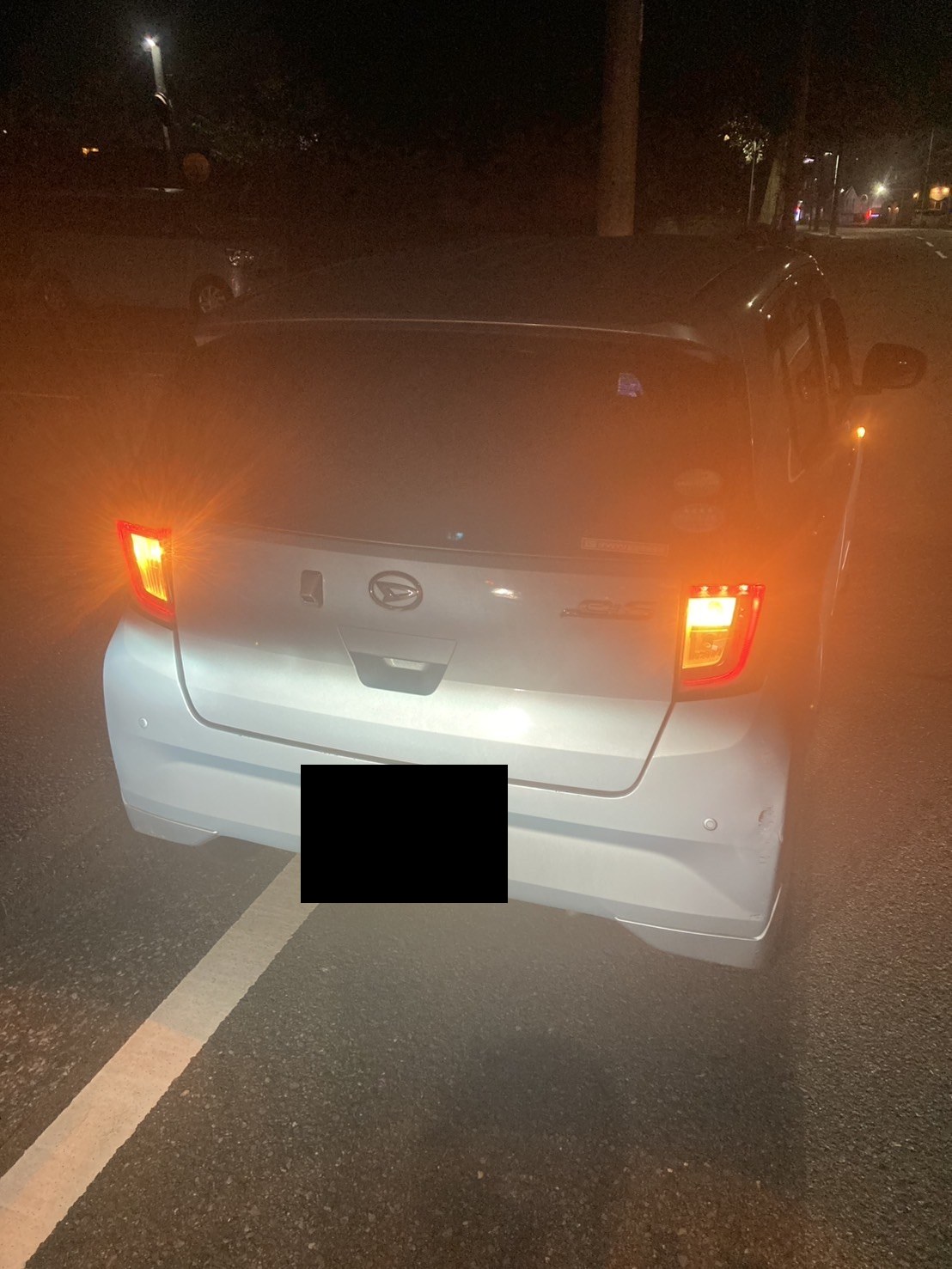 夜間、ハザードを点灯して路肩に停車した軽自動車を後方から見た様子（ナンバープレートはマスク処理）