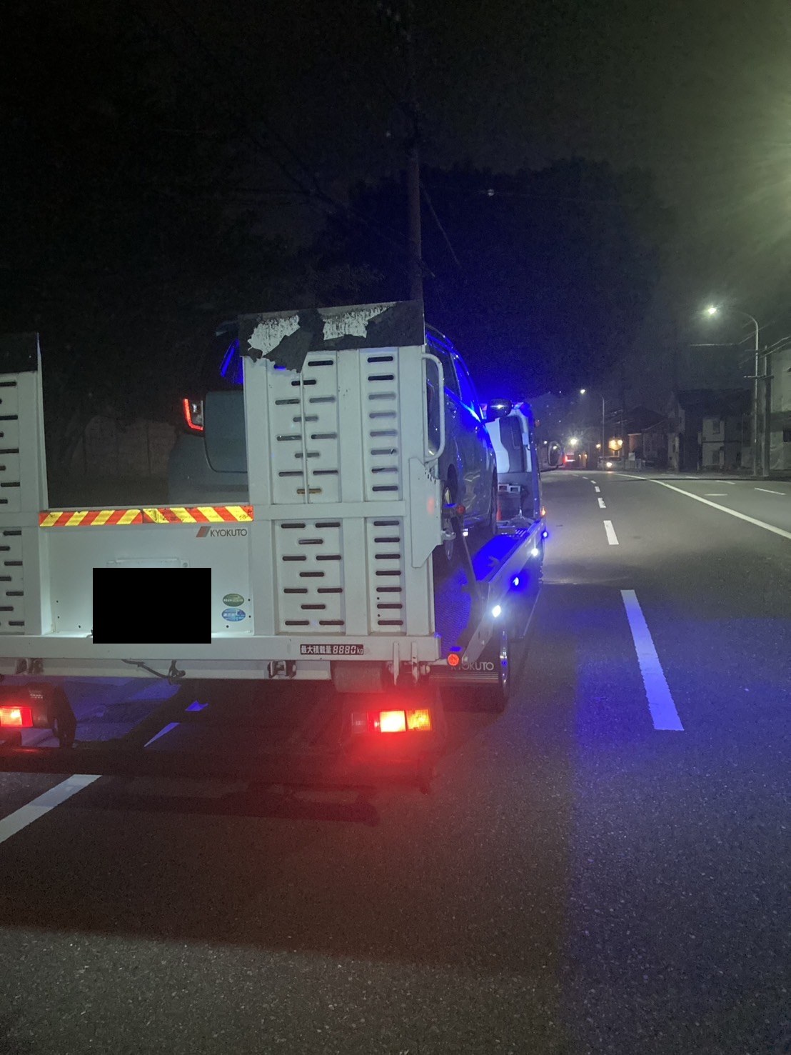 軽自動車を載せた積載車を斜め後方から見た様子（積載車のナンバープレートはマスク処理）