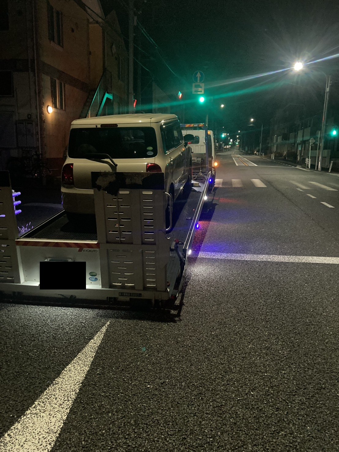 積載車の荷台に軽自動車を載せた夜の様子（積載車のナンバープレートはマスク処理）