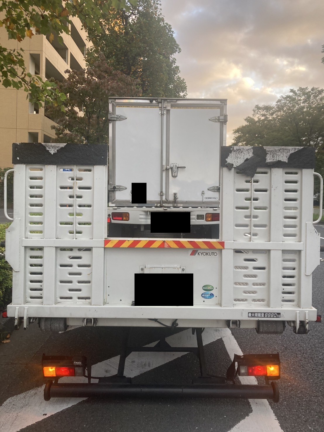 積載車の荷台に載せた軽トラックを後方から見た様子（お車と積載車のナンバープレートはマスク処理）