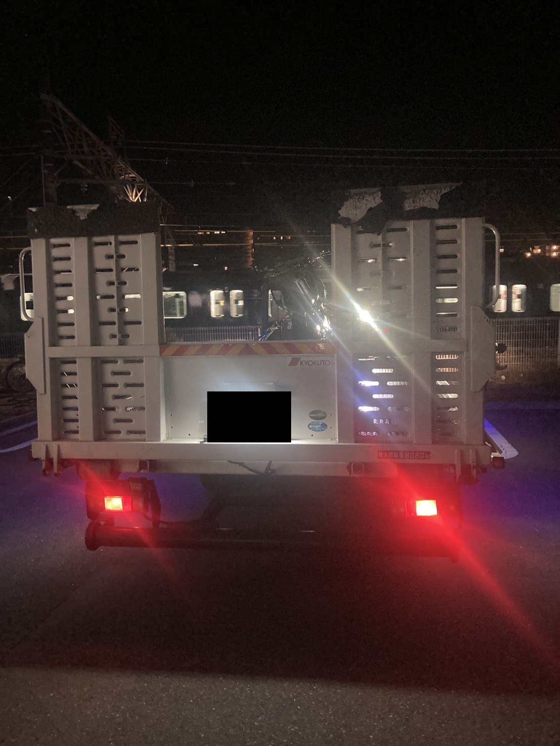 バイクを載せた夜間の積載車を後方から見た様子（積載車のナンバープレートはマスク処理）
