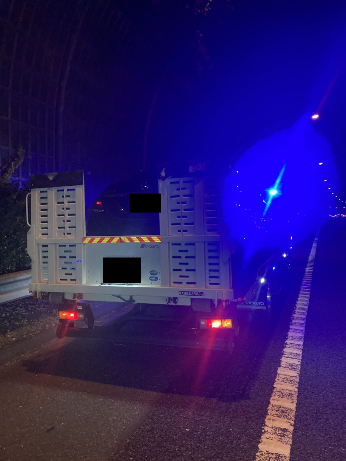 セダンを載せた積載車を後方から見た様子（お車と積載車のナンバープレートはマスク処理）